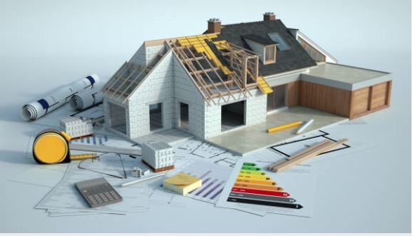 Maquette de maison en construction avec des outils et des plans autour.