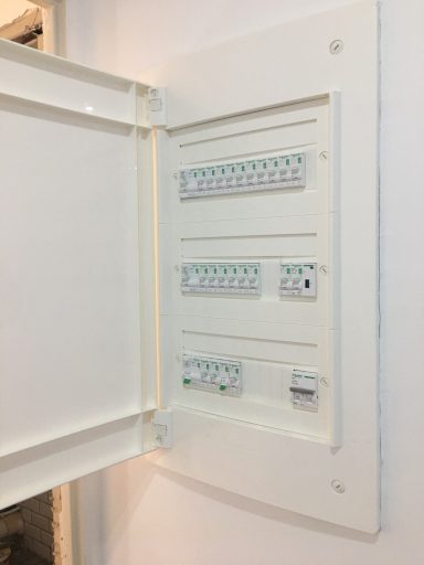 Tableau électrique blanc avec plusieurs disjoncteurs et indicateurs lumineux.