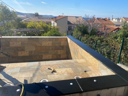 Vue d'une piscine en cours de construction, avec des maisons en arrière-plan.